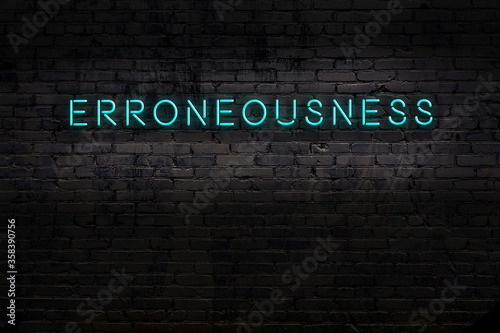 Neon sign. Word erroneousness against brick wall. Night view photo