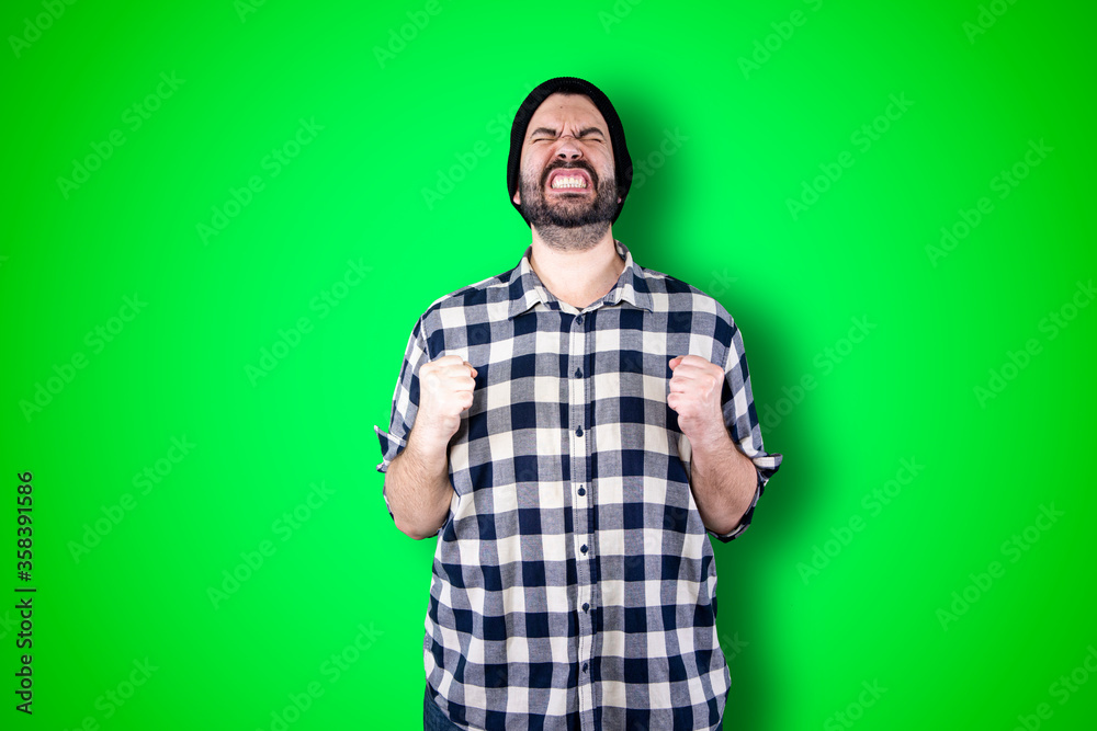 Portrait of a puzzled bearded man holding hands on his head isolated over chroma background Portrait of a puzzled bearded man holding hands on his head isolated over chroma background