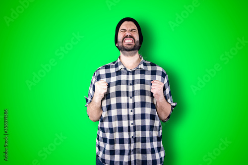 Canvastavla Portrait of a puzzled bearded man holding hands on his head isolated over chroma