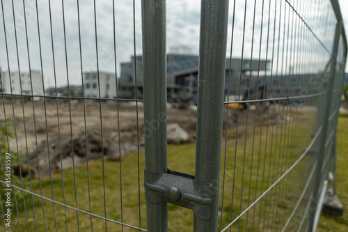 construction site seen trough metal bars with focus on metal bars in the foreground