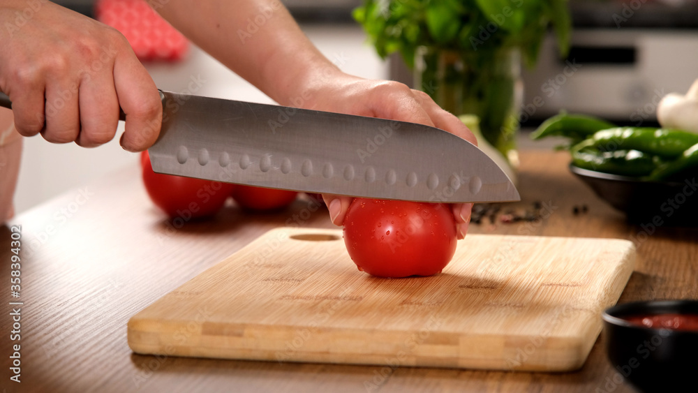 Female cutting tometoes. Knife and wooden. Cutting vegatable 
