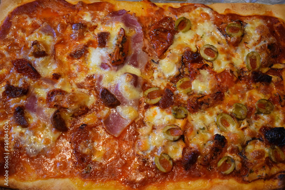 Piping hot hand baked at home Italian style non vegetarian pizza. Shop bought dough containing gluten with red ripe tomato and basil sauce Baby mozarella salami smoked bacon octopus carpaccio toppings Piping hot hand baked at home Italian style non vegetarian pizza. Shop bought dough containing gluten with red ripe tomato and basil sauce Baby mozarella salami smoked bacon octopus carpaccio toppings