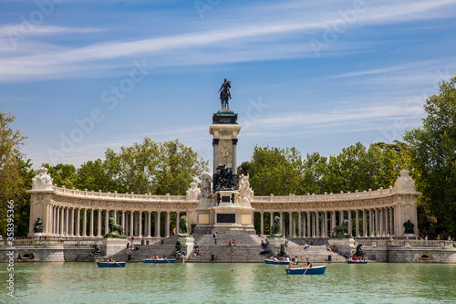 Tourists and locals enjoying a beautiful spring day sailing at the Retiro Park pond