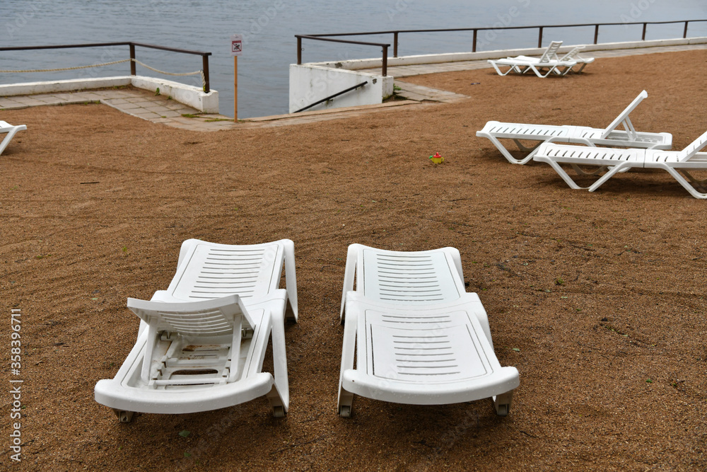 sandy beach with umbrellas and sunbeds on the banks of the river sandy beach with umbrellas and sunbeds on the banks of the river