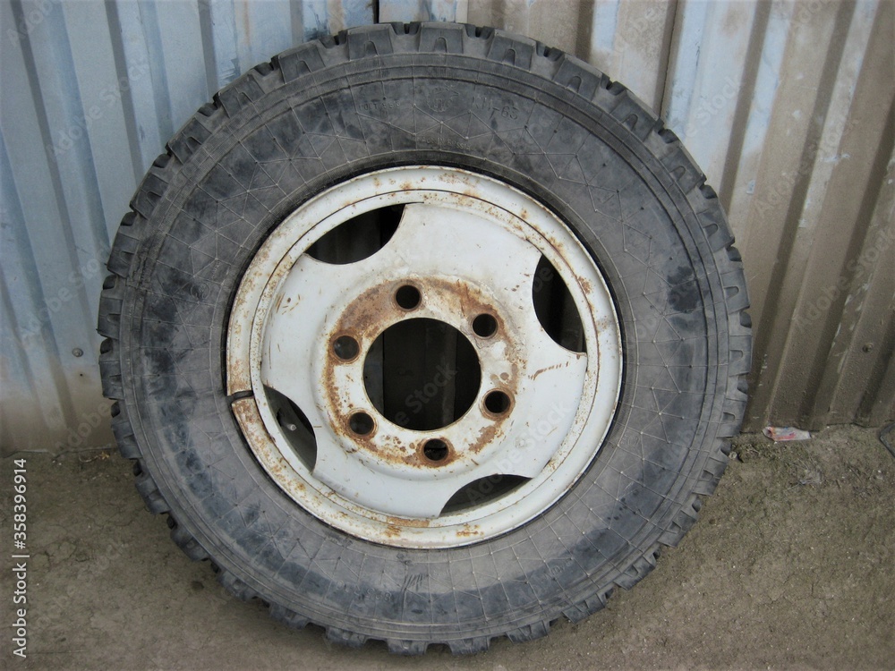 an old abandoned big car wheel in an old dirty garage
