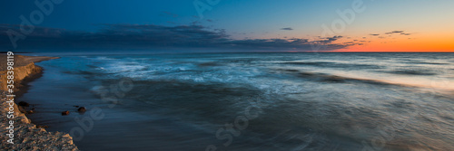 Waiting for sunrise on the beach in Chalupy. A quiet and peaceful place ideal for rest and relaxation. Famous naturist beach. Widescreen(panoramic) banner of vacations landscape.