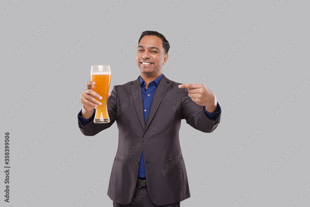 Businessman Pointing at Beer Glass. Indian Business man with Beer in Hand Businessman Pointing at Beer Glass. Indian Business man with Beer in Hand