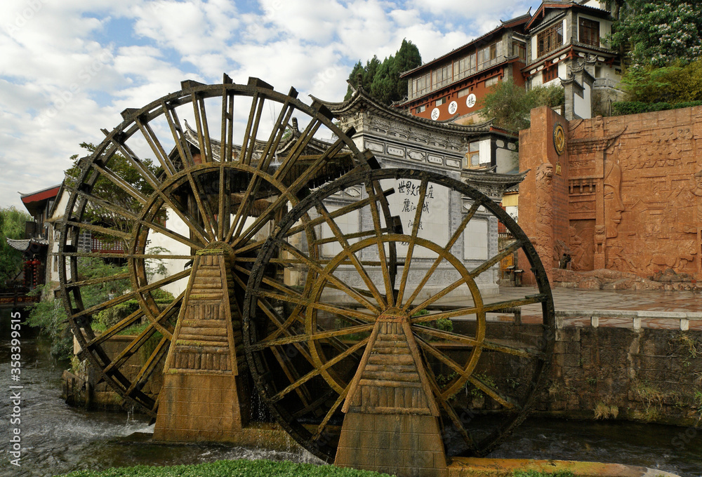 Old wood water wheels turn on a rushing creek in the ancient Naxi town of Lijiang (Dayan), Yunnan Province, China.