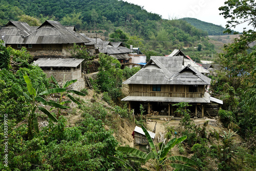 Wood houses with tin roofs in a Jinuo ethnic minority village, Xishuangbanna, Yunnan Province, China photo