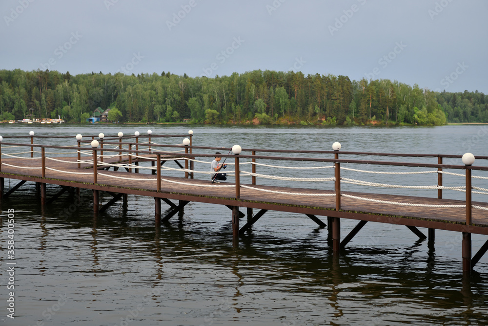landscape with a pier on the river and forest