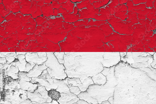 Indonesia flag close up grungy, damaged and weathered on wall peeling off paint to see inside surface. Vintage concept.