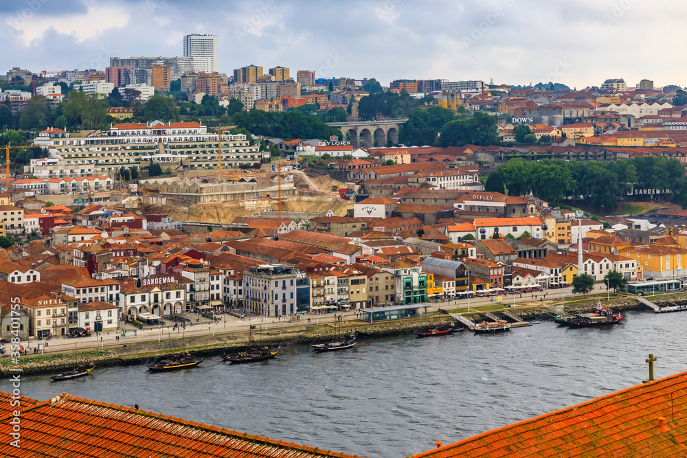 View over terracotta roofs across Douro onto the famous Portuguese wine cellars in Vila Nova de Gaia, Porto, Portugal