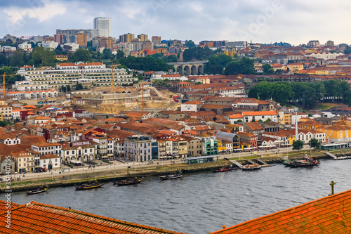 View over terracotta roofs across Douro onto the famous Portuguese wine cellars in Vila Nova de Gaia, Porto, Portugal