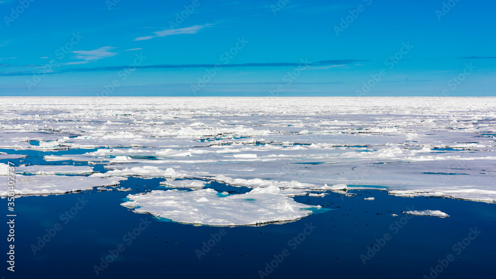 Blue sky and Ice pieces on the water in Arctic