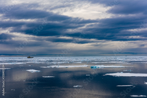 Cloudy sky and Ice pieces on the water in Arctic