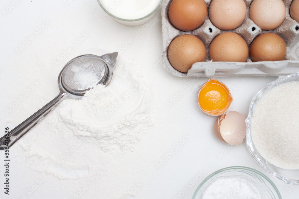Baking ingredients: flour, eggs, sugar, butter, milk and spices on gray marble background Baking ingredients: flour, eggs, sugar, butter, milk and spices on gray marble background