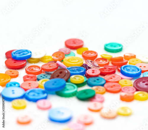 Bright buttons a lot on a white background . Sewing and needlework. Colored buttons
