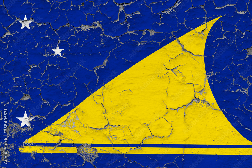 Tokelau flag close up grungy, damaged and weathered on wall peeling off paint to see inside surface. Vintage concept.
