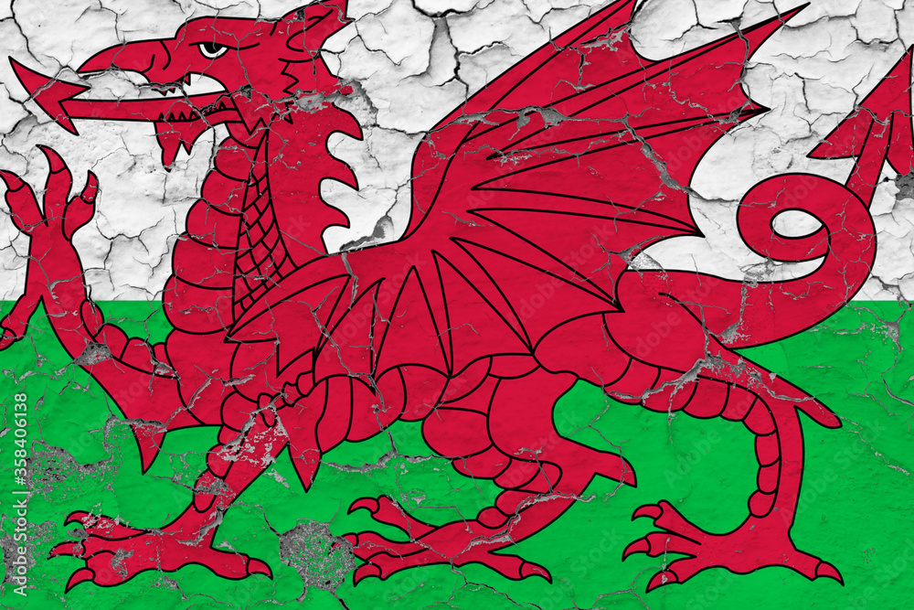 Wales flag close up grungy, damaged and weathered on wall peeling off paint to see inside surface. Vintage concept. Wales flag close up grungy, damaged and weathered on wall peeling off paint to see inside surface. Vintage concept.