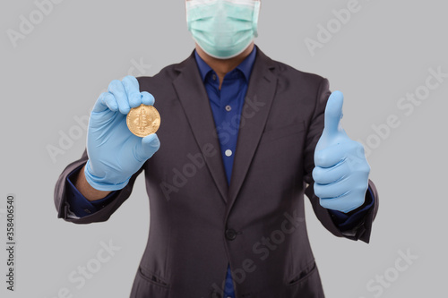 Businessman Showing Bitcoin and Thumb Up Wearing Medical Mask and Gloves. Business man Cypto Currency.