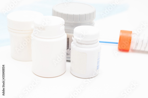 medical jars with pills on white table