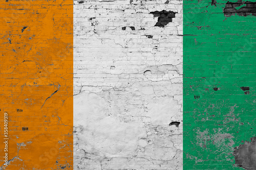 Cote D'Ivoire flag on grunge scratched concrete surface. National vintage background. Retro wall concept. © sezerozger