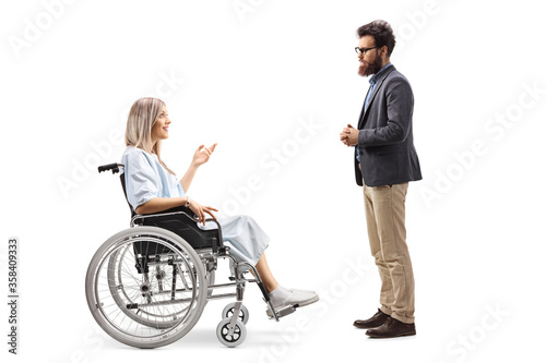 Female patient in a wheelchair talking to a bearded man