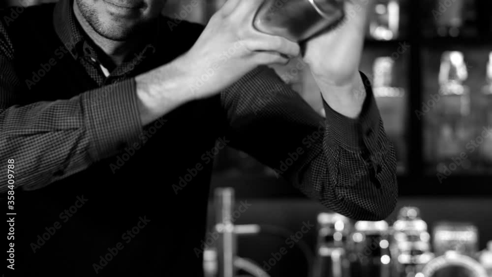 Bartender shaking cocktail in cocktail shaker at bar, black and white Bartender shaking cocktail in cocktail shaker at bar, black and white