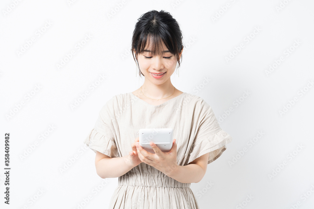 電卓で計算する若い女性 電卓で計算する若い女性
