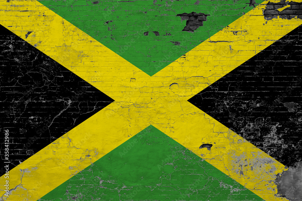 Jamaica flag on grunge scratched concrete surface. National vintage background. Retro wall concept.