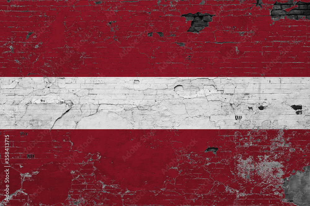 Latvia flag on grunge scratched concrete surface. National vintage background. Retro wall concept.