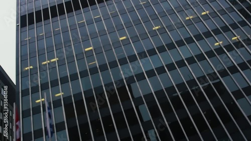 TORONTO, CANADA - MAY 14 2019 Worms eye angle tracking shot shot of skyscrapers over from street view. A stark city over an overcast sky 