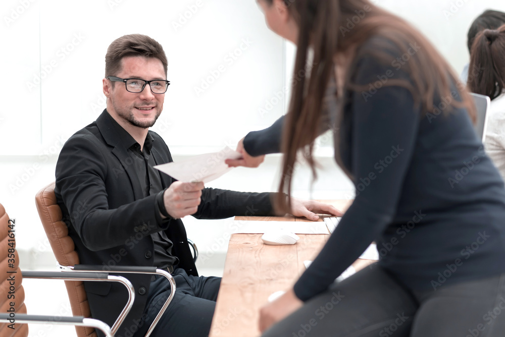 smiling young business woman standing near the desktop smiling young business woman standing near the desktop