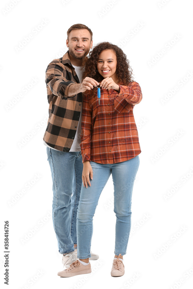Happy young couple with car key on white background Happy young couple with car key on white background