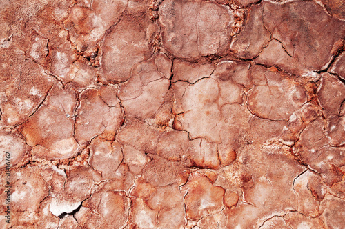 Background of red cracked clay dried in a quarry. Texture.