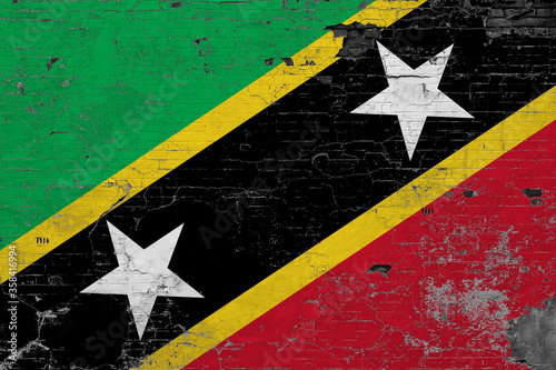 Saint Kitts And Nevis flag on grunge scratched concrete surface. National vintage background. Retro wall concept. photo