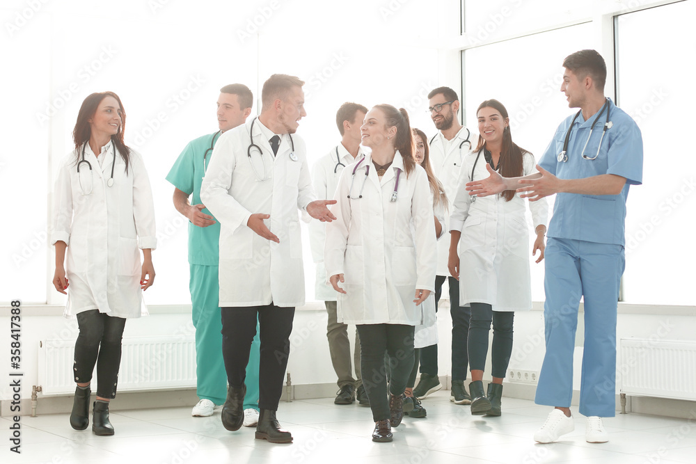young medical doctors striding through the hospital corridor young medical doctors striding through the hospital corridor