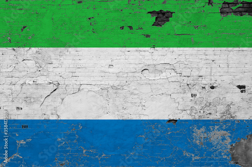 Sierra Leone flag on grunge scratched concrete surface. National vintage background. Retro wall concept.