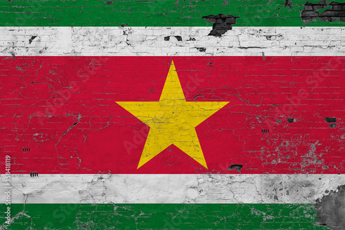 Suriname flag on grunge scratched concrete surface. National vintage background. Retro wall concept.