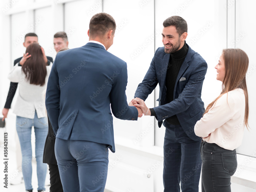 business partners holding out their hands for a handshake business partners holding out their hands for a handshake