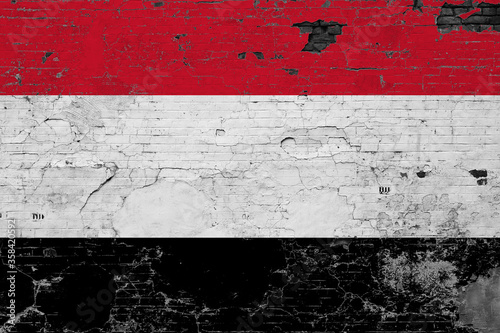 Yemen flag on grunge scratched concrete surface. National vintage background. Retro wall concept.