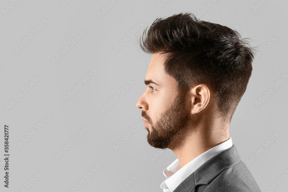 Handsome man with stylish hairdo on grey background Handsome man with stylish hairdo on grey background
