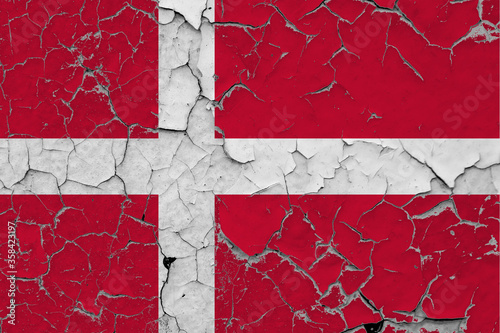 Denmark flag close up grungy, damaged and scratched on wall peeling off paint to see inside surface. Vintage National Concept.