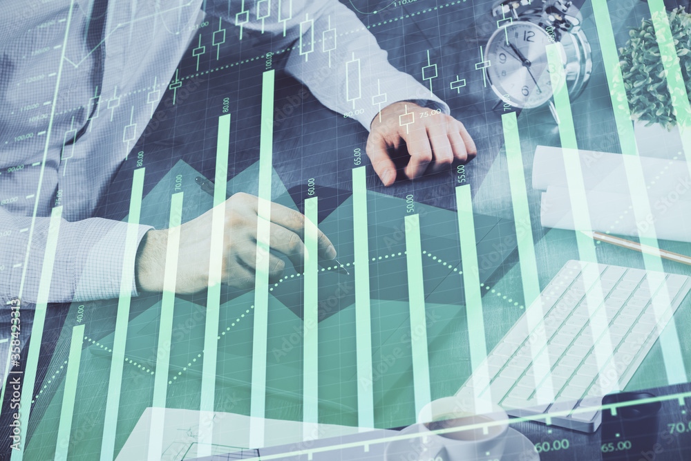 Double exposure of man's hands holding and using a phone and financial graph drawing. Analysis concept. Double exposure of man's hands holding and using a phone and financial graph drawing. Analysis concept.