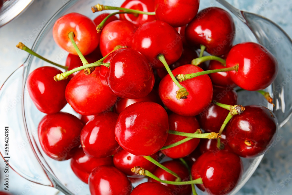 Glassware with sweet cherry on color background, closeup Glassware with sweet cherry on color background, closeup