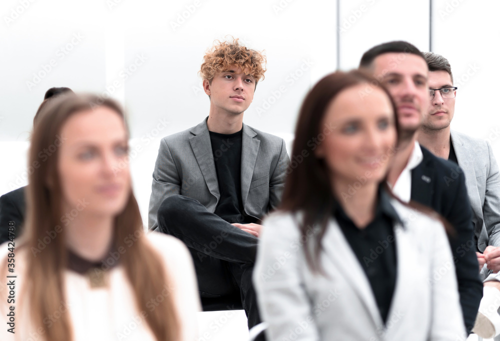 group of employees sitting in a conference room. group of employees sitting in a conference room.