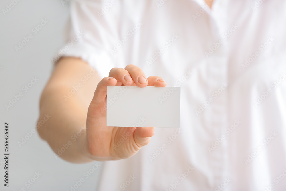 Woman with blank business card, closeup