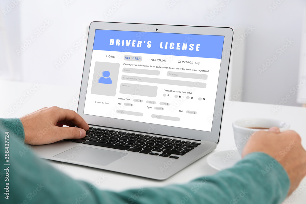 Man filling in driver's license form online on website using laptop, closeup Man filling in driver's license form online on website using laptop, closeup