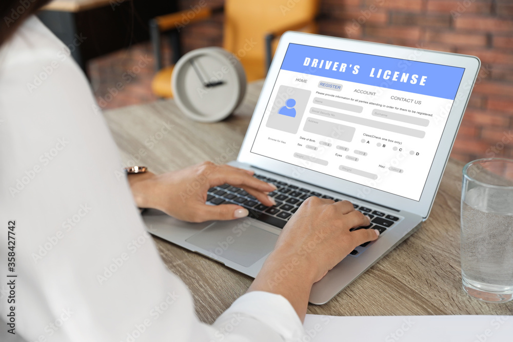 Woman filling in driver's license form online on website using laptop, closeup Woman filling in driver's license form online on website using laptop, closeup
