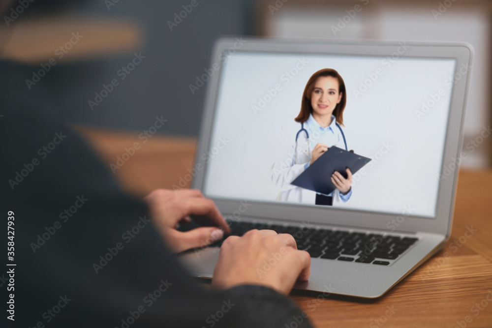 Woman using laptop for online consultation with mature female doctor, closeup Woman using laptop for online consultation with mature female doctor, closeup